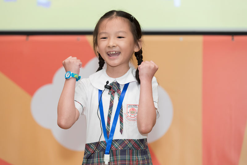 高小組決賽参賽者何慧琳小朋友舉高雙手，緊握著拳頭。